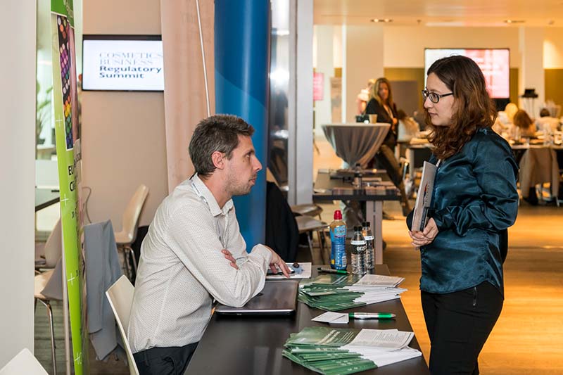 Delphic representatives talking to a delegate in 2018